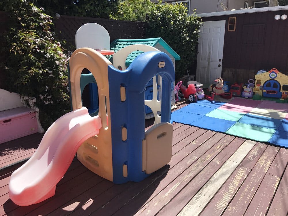 Children's play structure with slide on a wooden deck