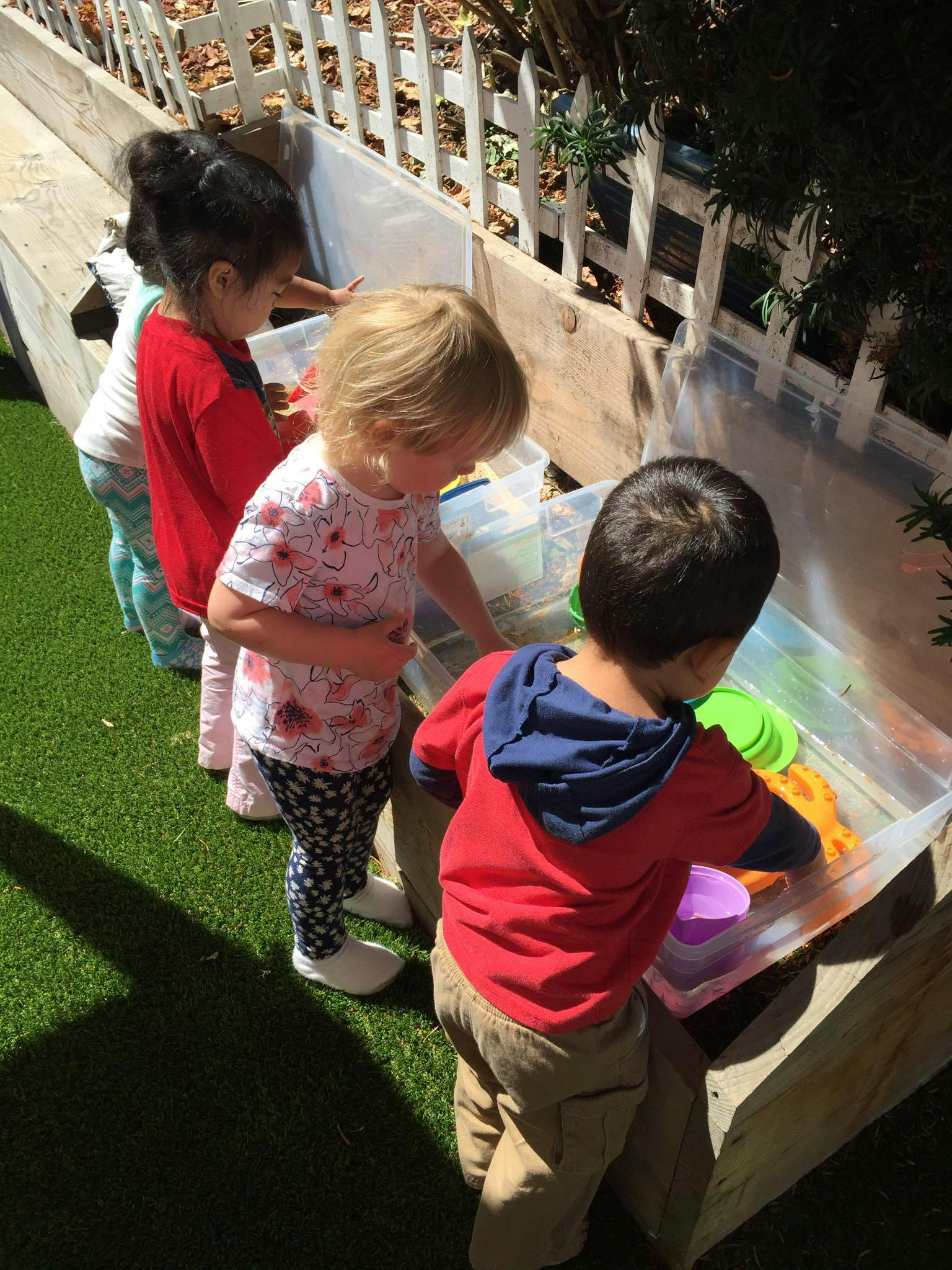Children playing with toys in a water trough