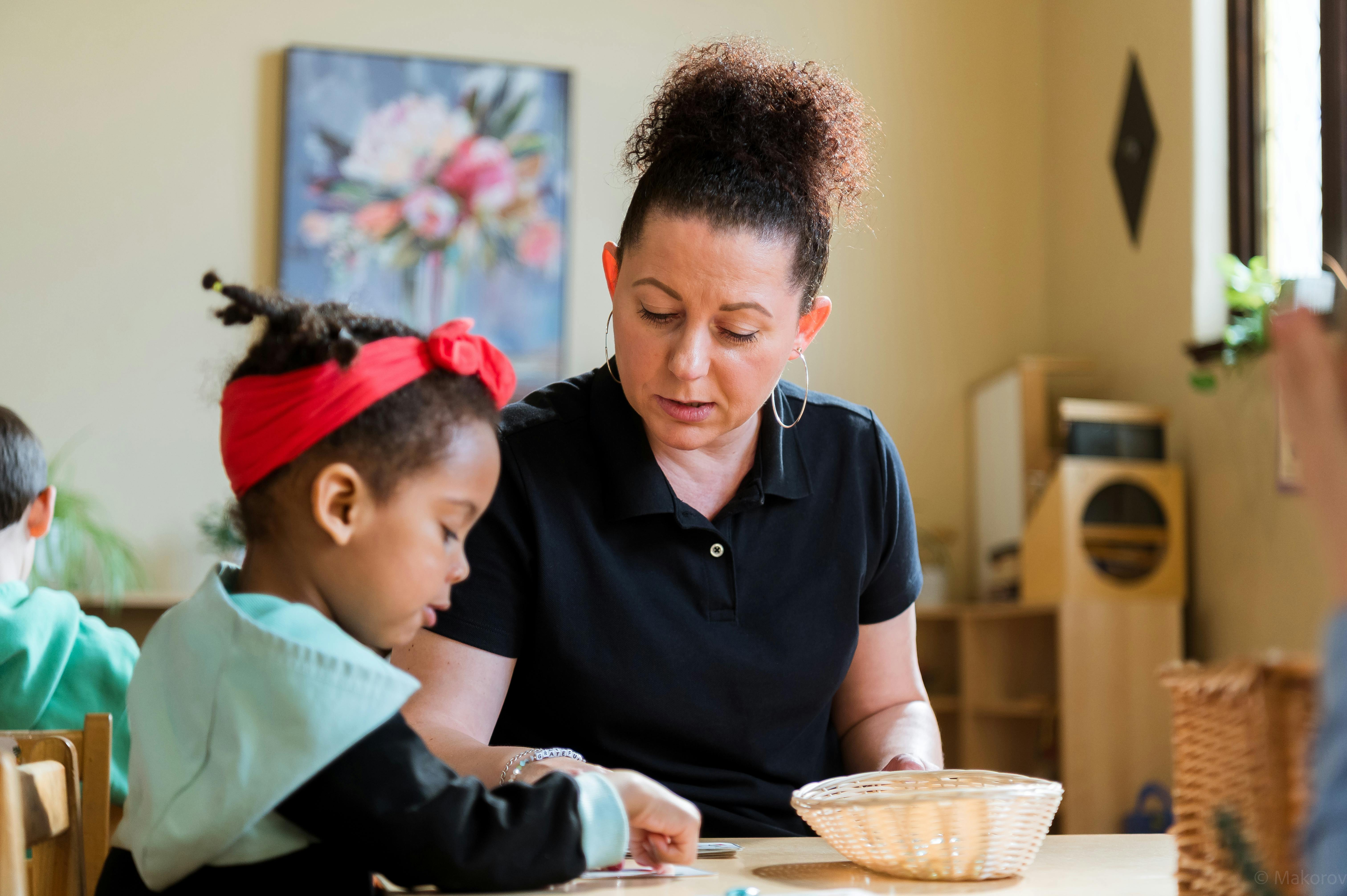 Adult and child at a table, adult looking at child