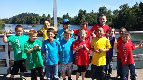 Group of children posing outdoors near water