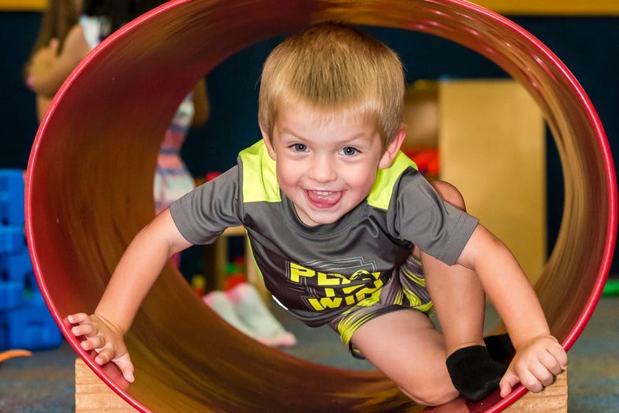 Child crawling through a red tunnel