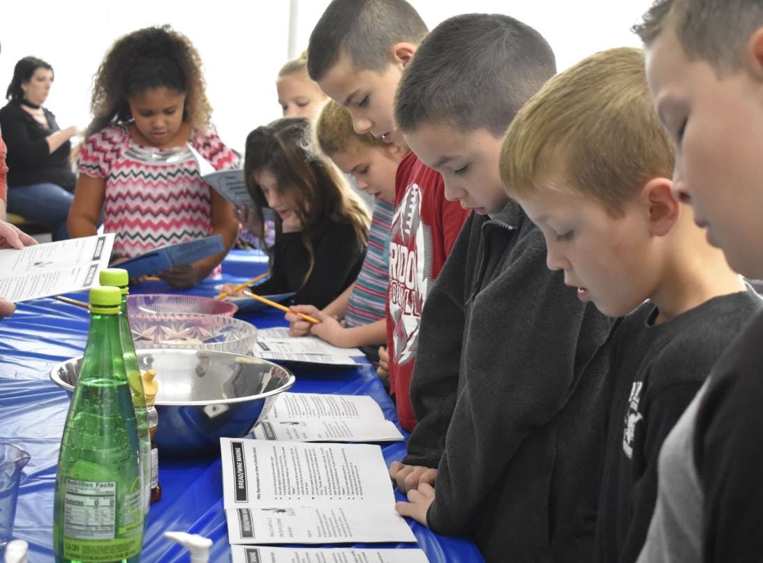 Children and teens looking at papers on a table