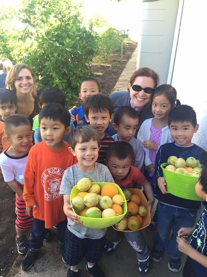 Adults and children holding bowls of fruit