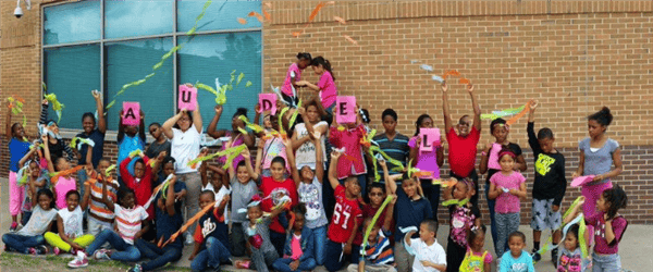 Group of children holding up signs and streamers