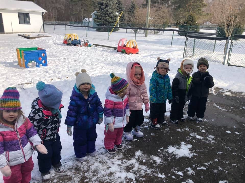 Group of children in winter clothing standing in snow