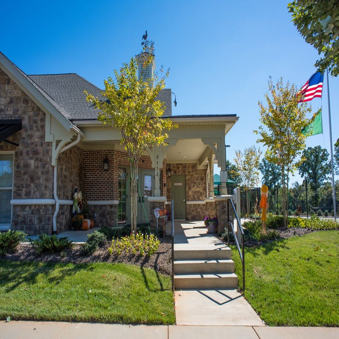 Brick building with a porch and steps leading to a door