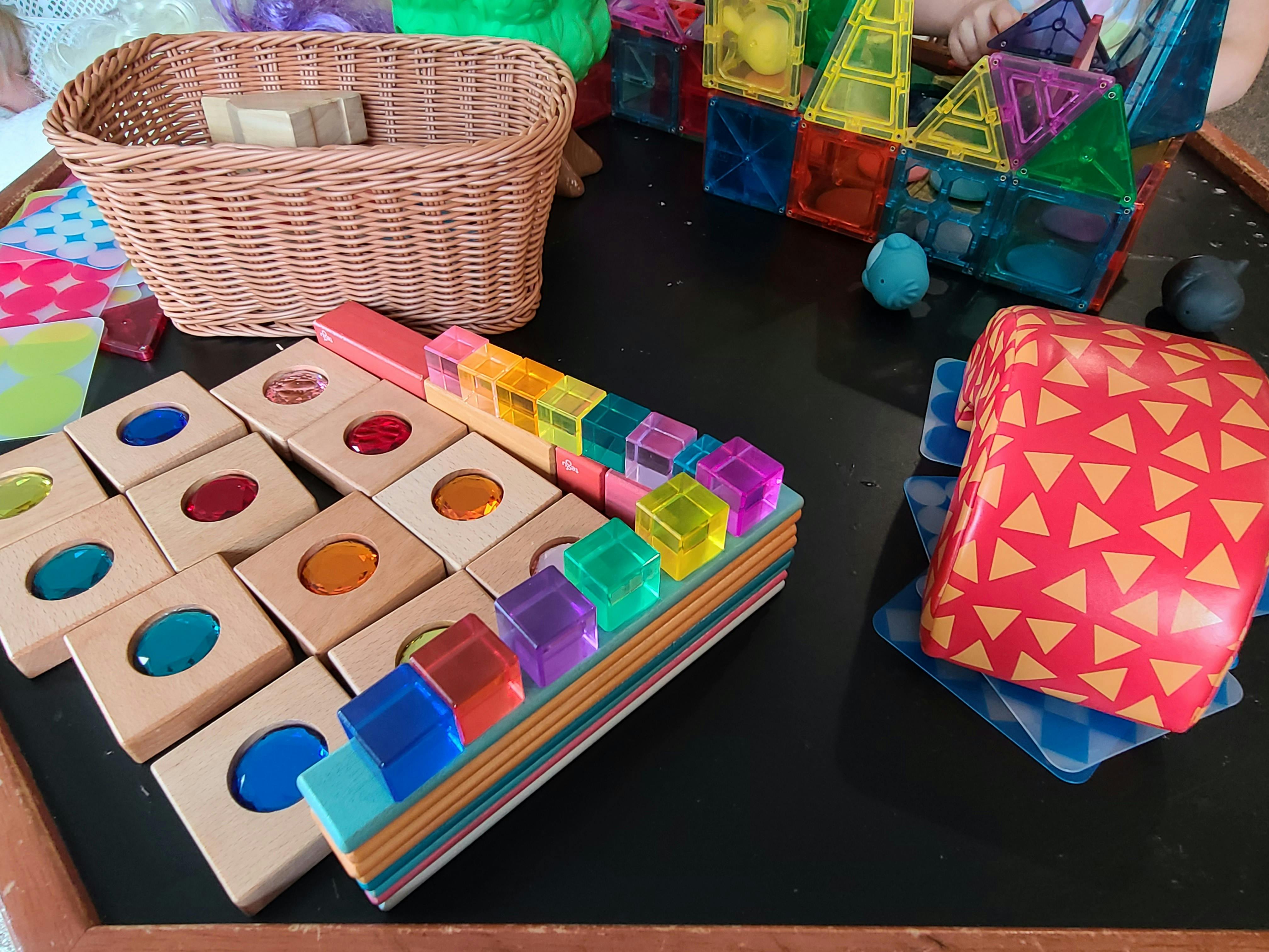 Wooden blocks with colored inserts and clear colorful blocks on a table
