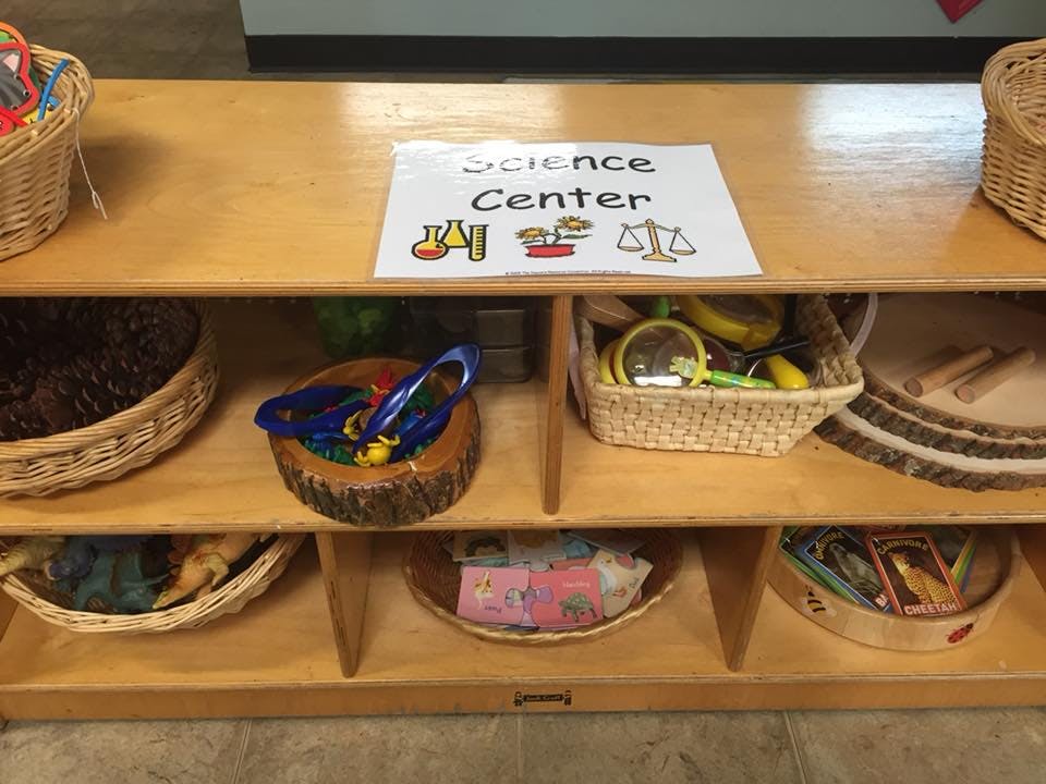 Science Center sign on a wooden shelf with baskets of items
