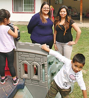 Two adults and two children playing on an outdoor play structure