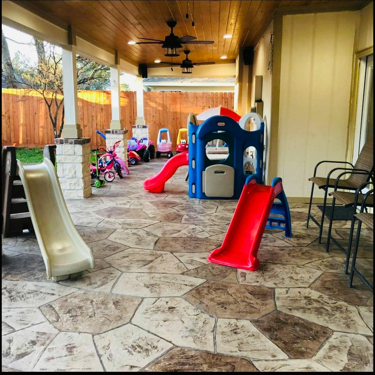 Outdoor patio with multiple slides and play structures