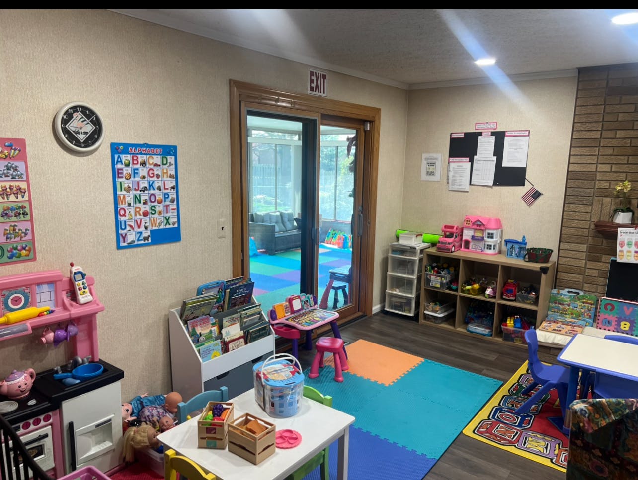 Children's play area with toy kitchen, bookshelf, and small tables