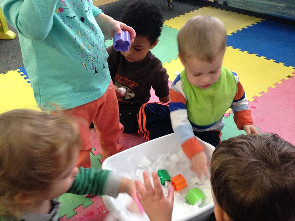 Children playing with sensory bin in a classroom