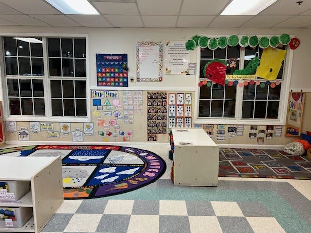 Classroom with calendar, weather charts, and a large circular rug
