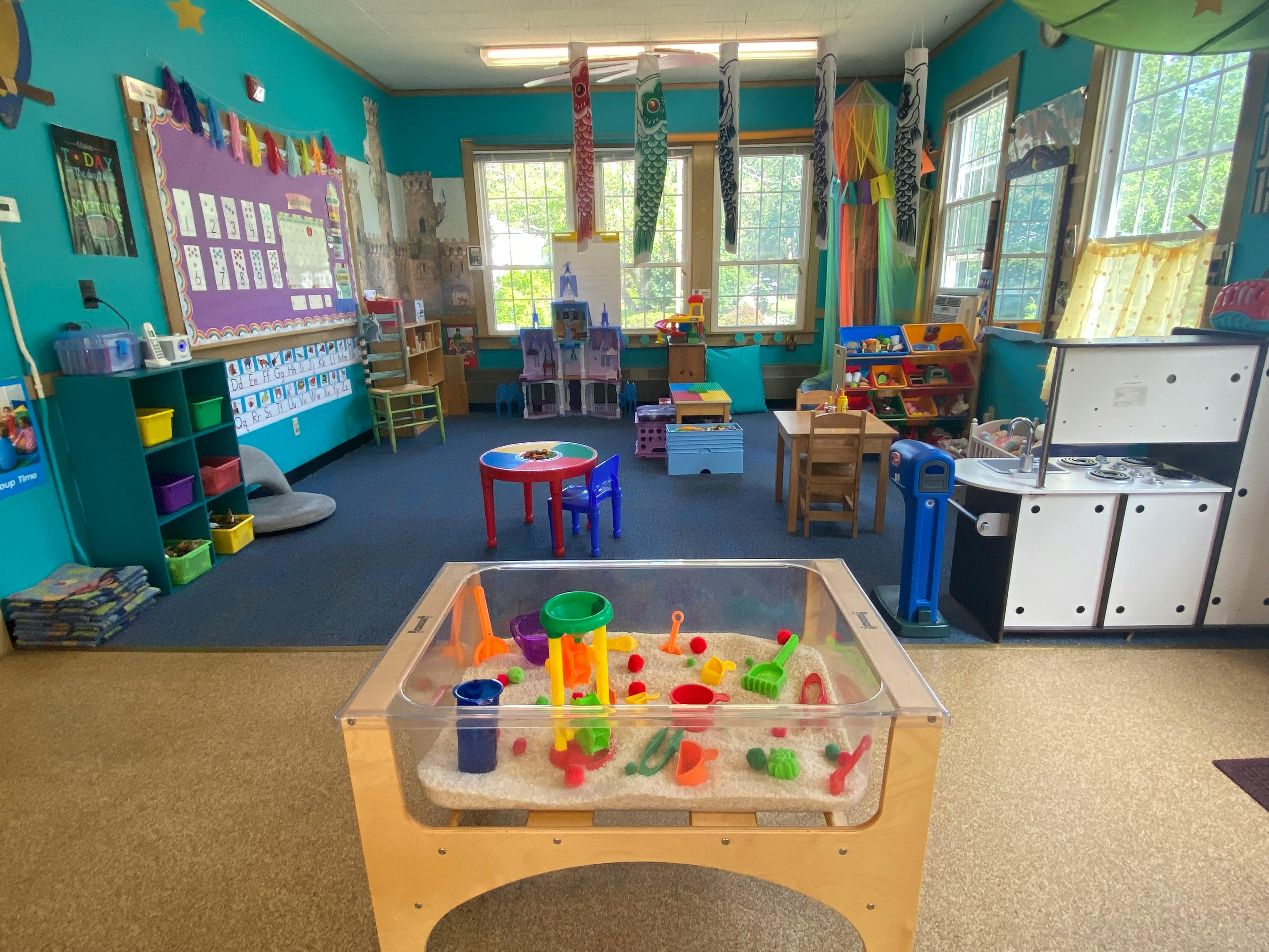 Playroom with a sand and water table in the foreground