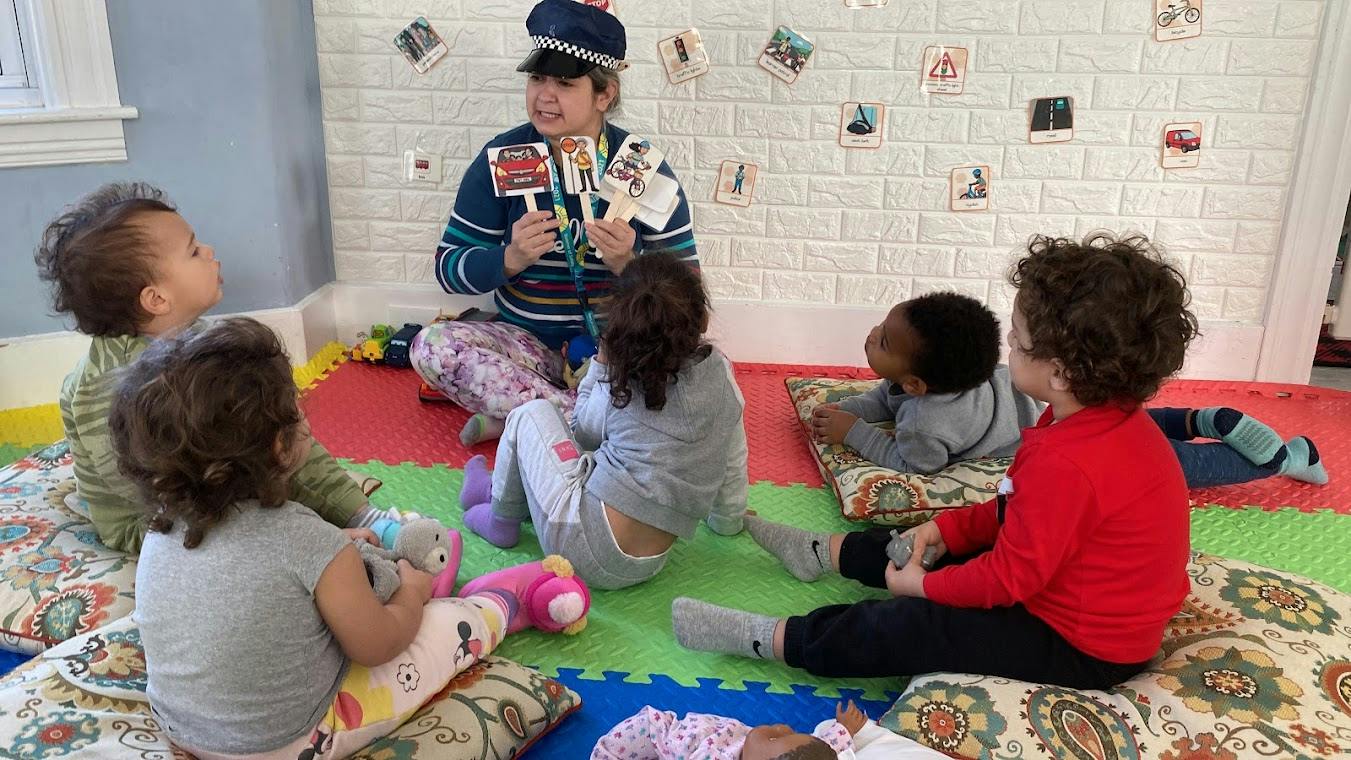 Adult leading a lesson with children in a classroom using visual cards