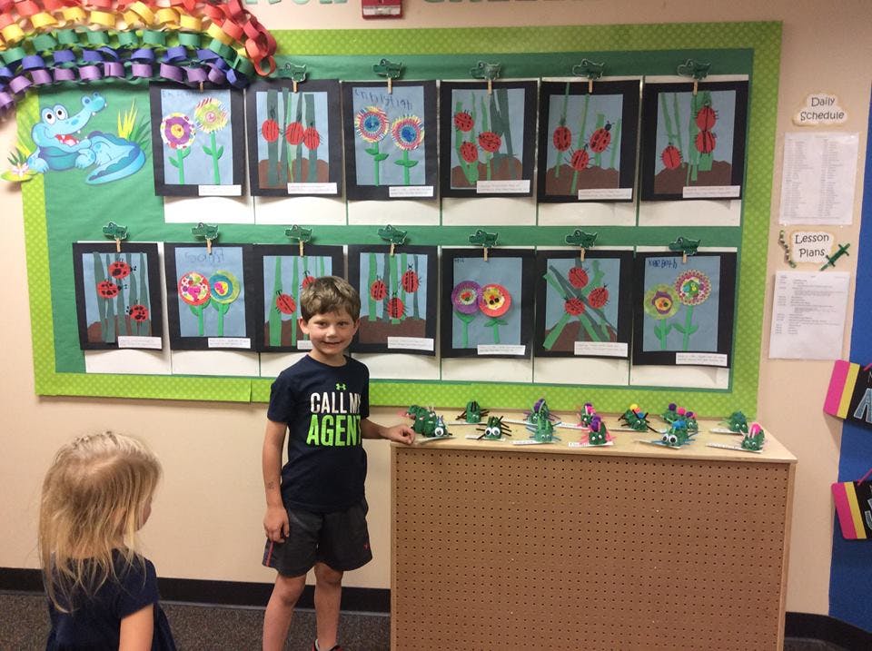 Child standing in front of a display of artwork