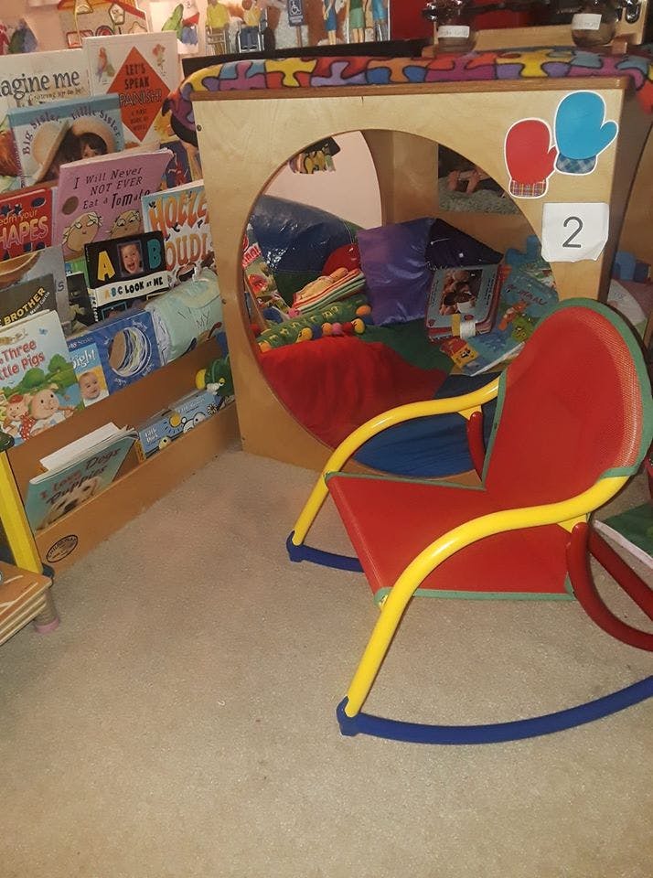 Children's reading nook with books and a small rocking chair