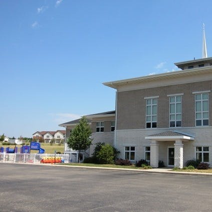 Building exterior with a steeple and a playground in the background