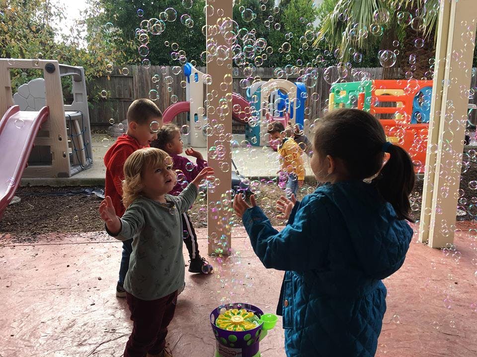 Children playing with bubbles outdoors