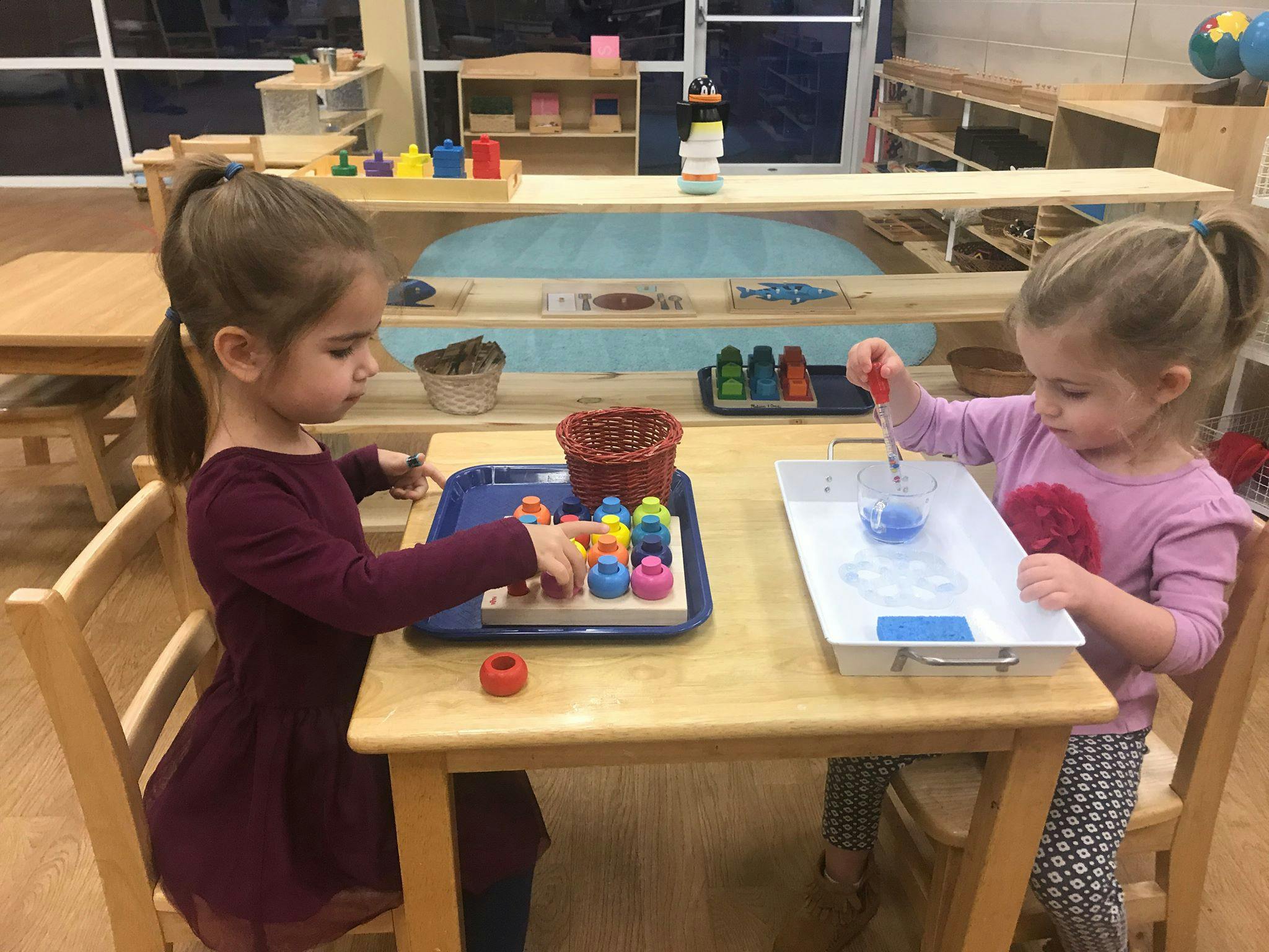 Two children playing with educational toys at a table