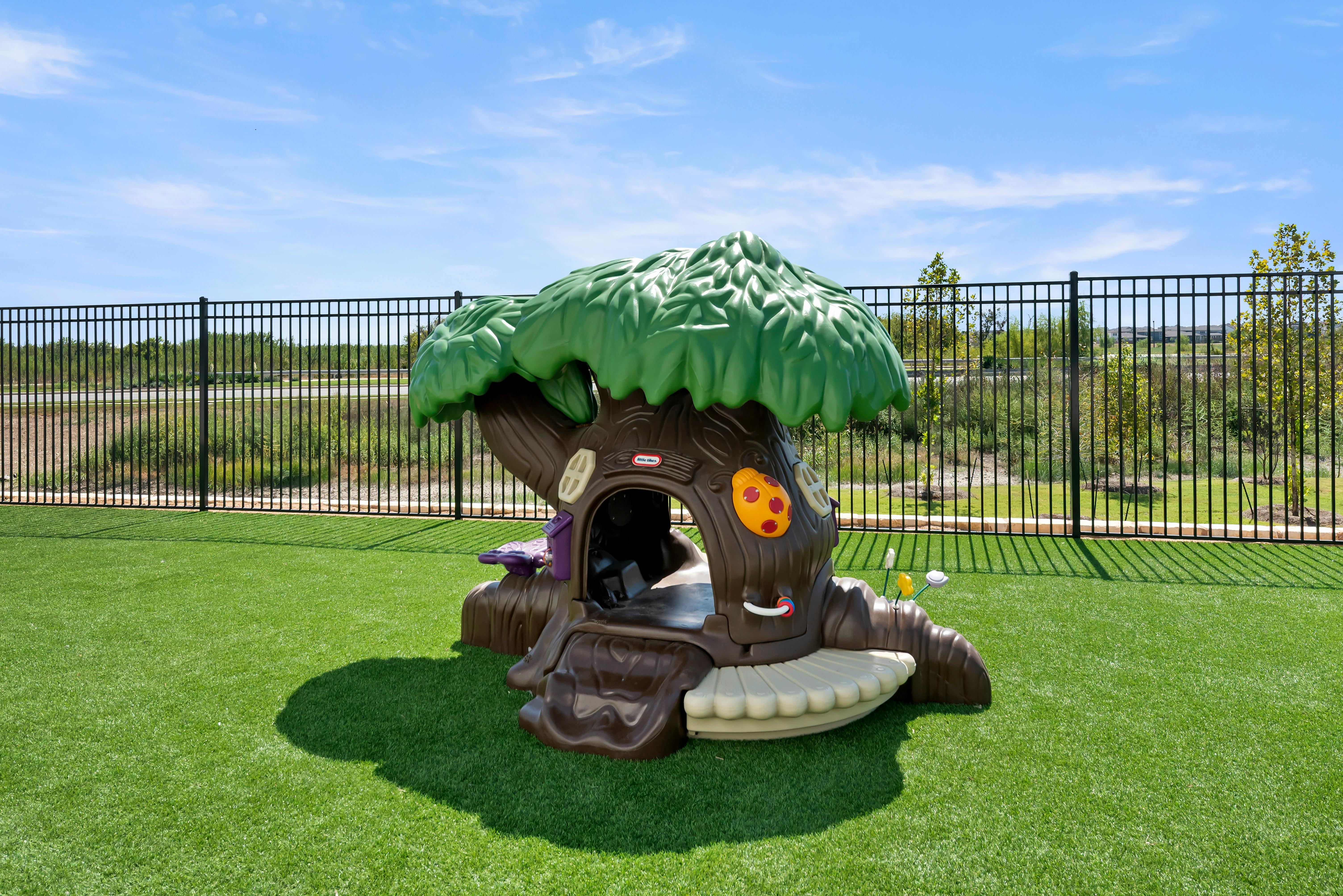 Plastic treehouse play structure on artificial grass