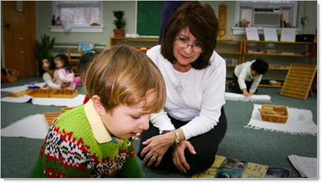 Adult and child on floor in classroom