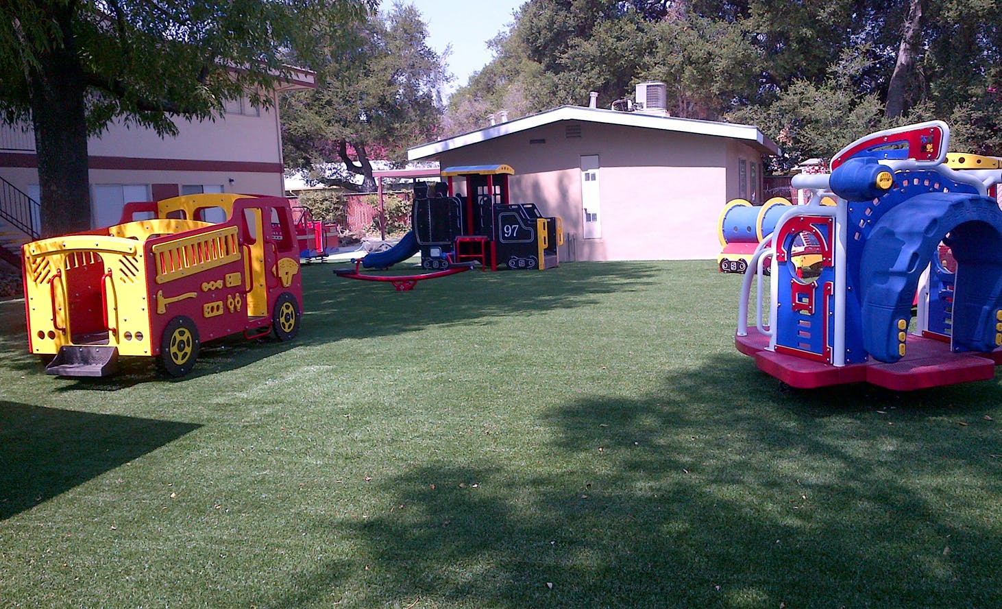 Playground with a red and yellow play truck and blue inflatable play structure