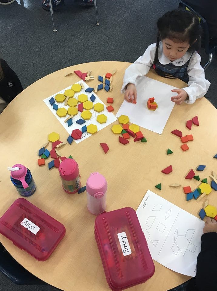 Child playing with colorful geometric shapes on a table