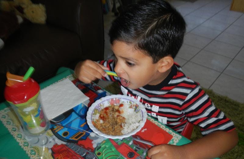 Child eating from a bowl with a spoon