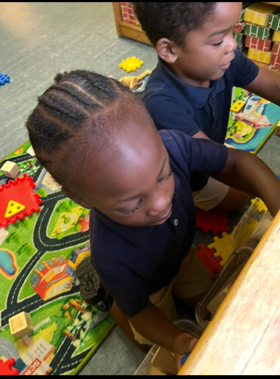Two children playing with toys on a mat