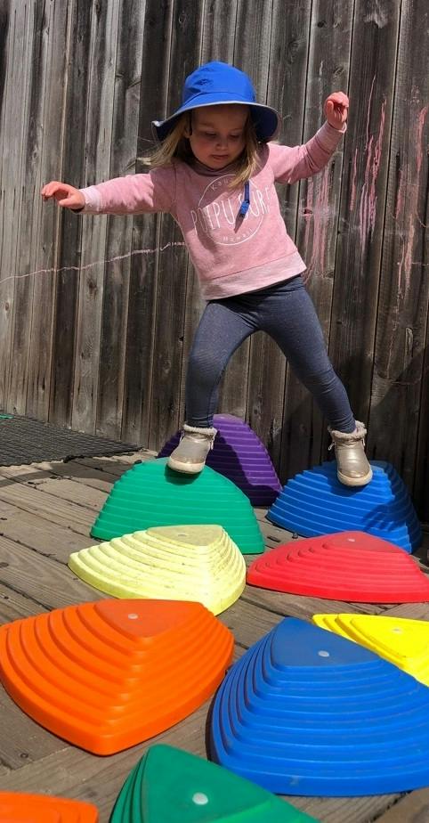 Child balancing on colorful stepping stones