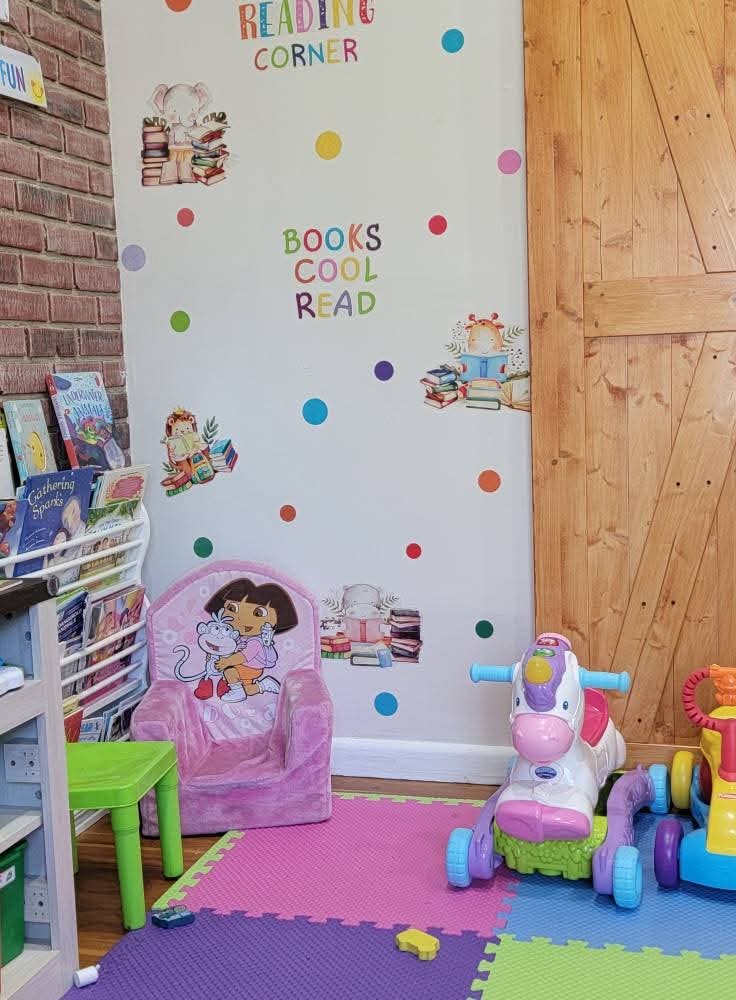 Reading corner with children's books and toys on colorful floor mats