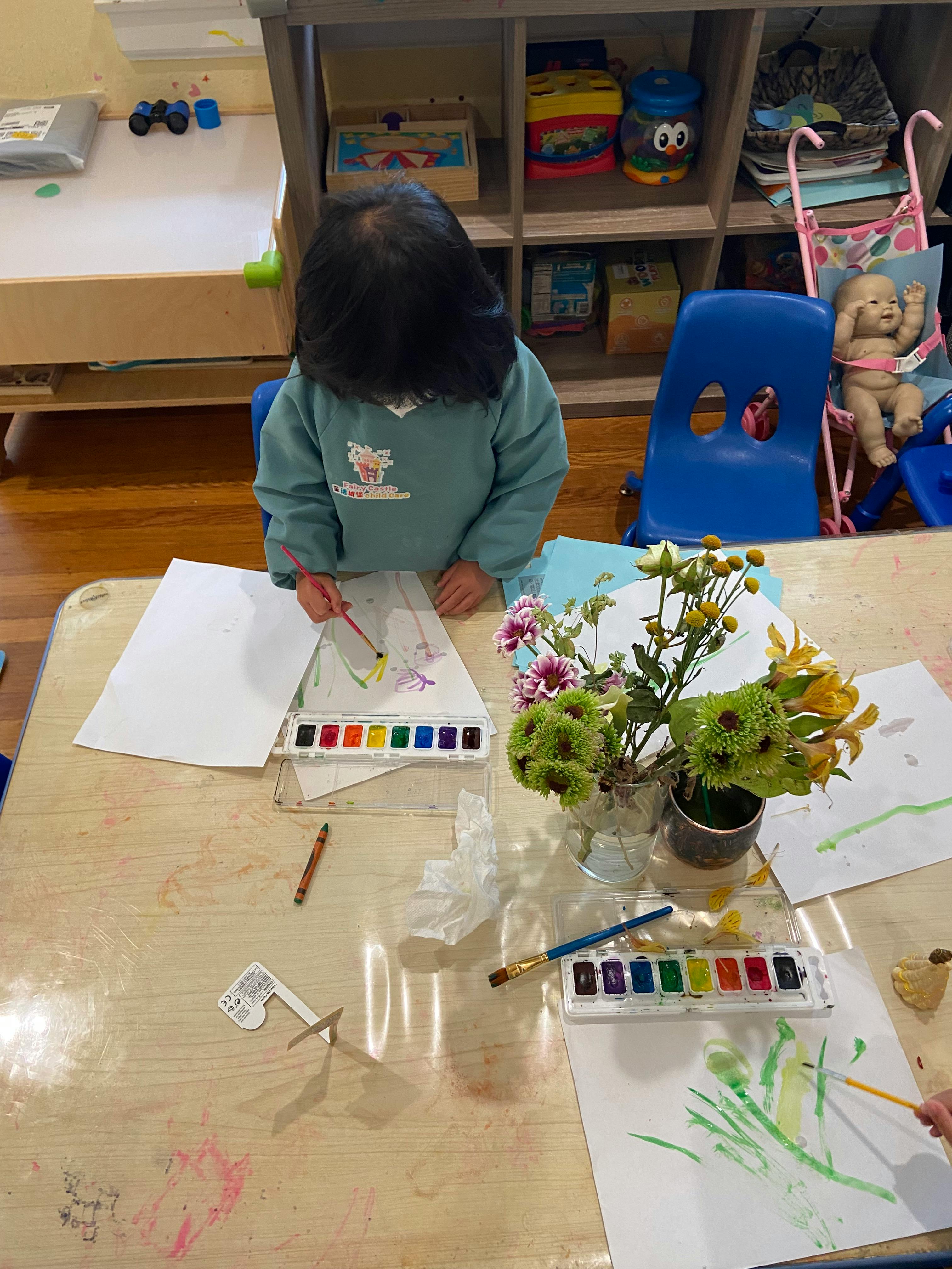Child painting with watercolors at a table