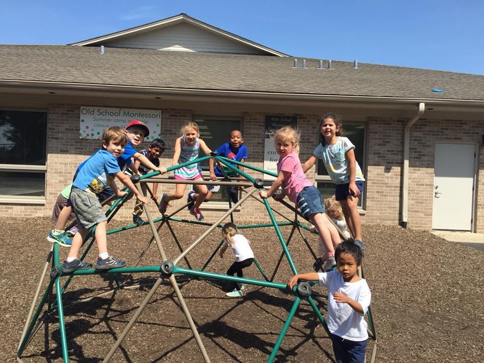Children playing on a geodesic dome climber on a playground
