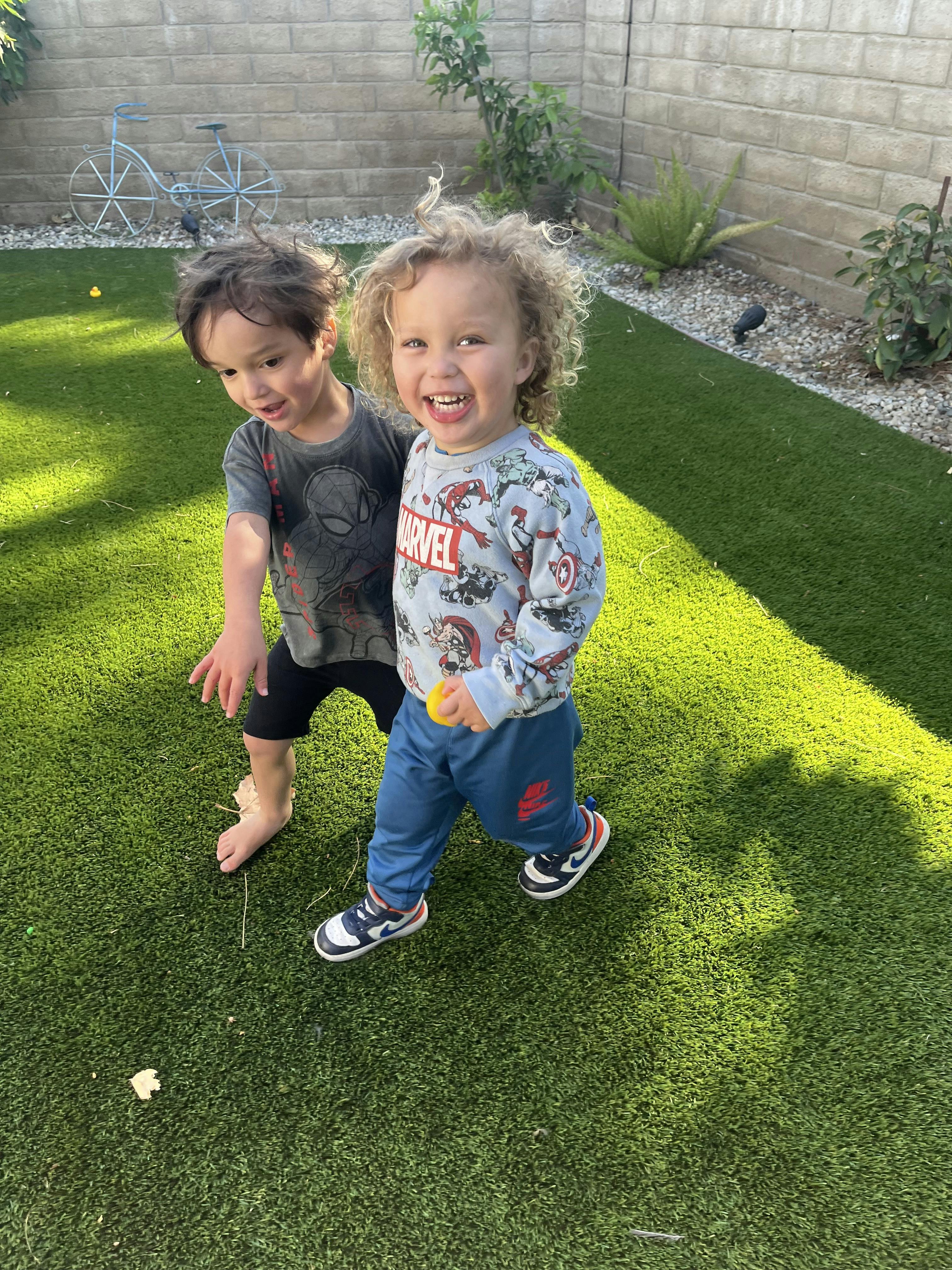 Two children playing on artificial grass