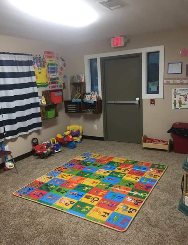 Playroom with colorful alphabet rug and toys