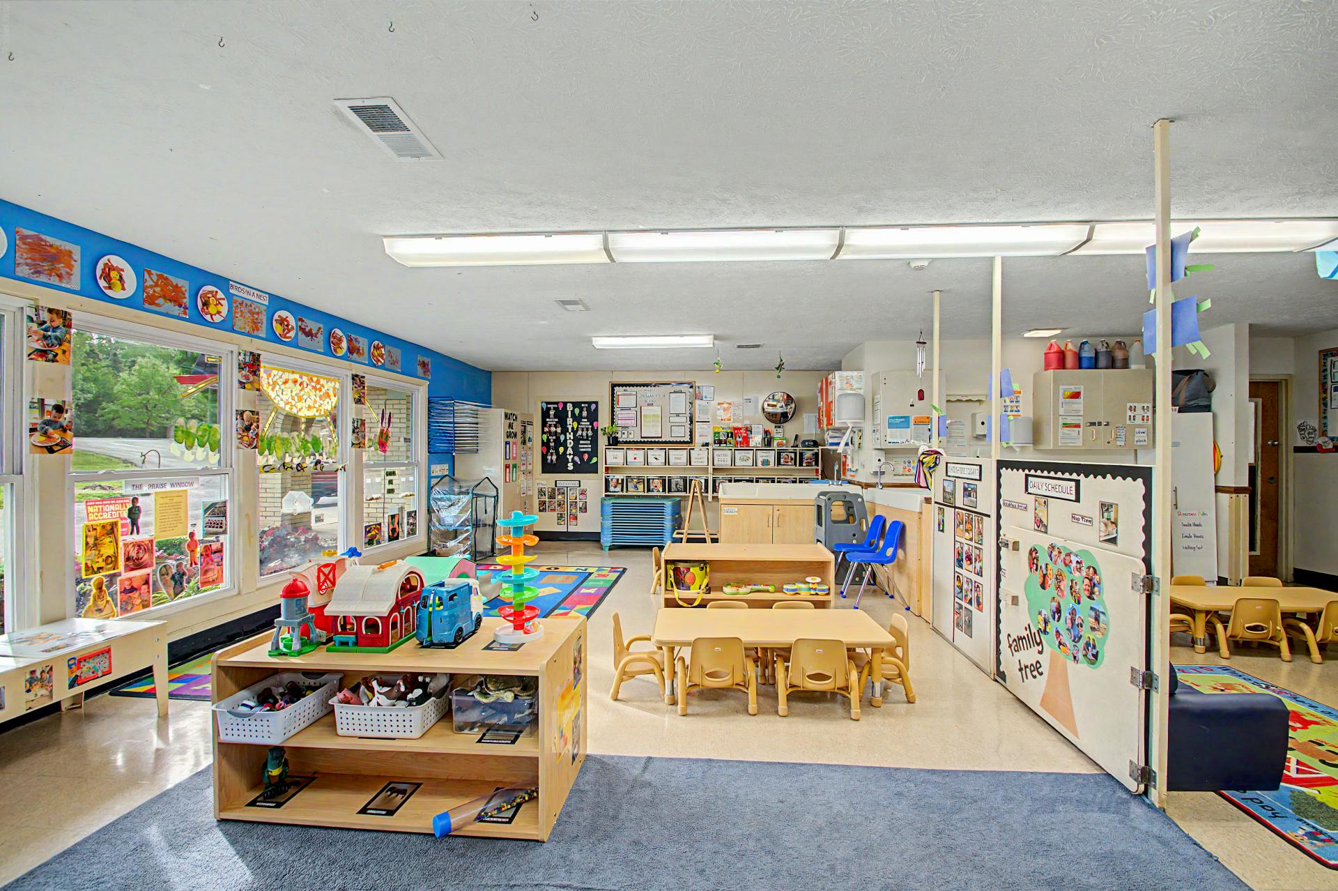 Classroom with small tables, chairs, and play areas
