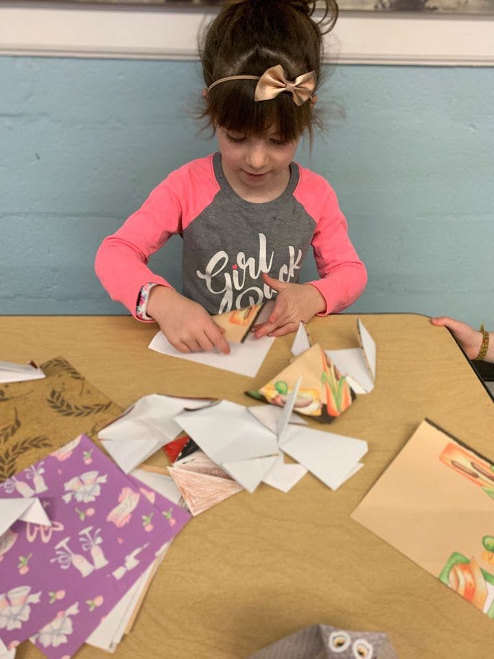 Child cutting paper at a table