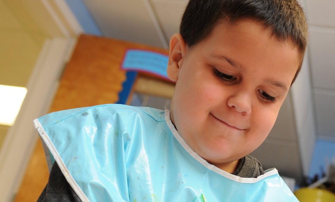 Child wearing a light blue bib