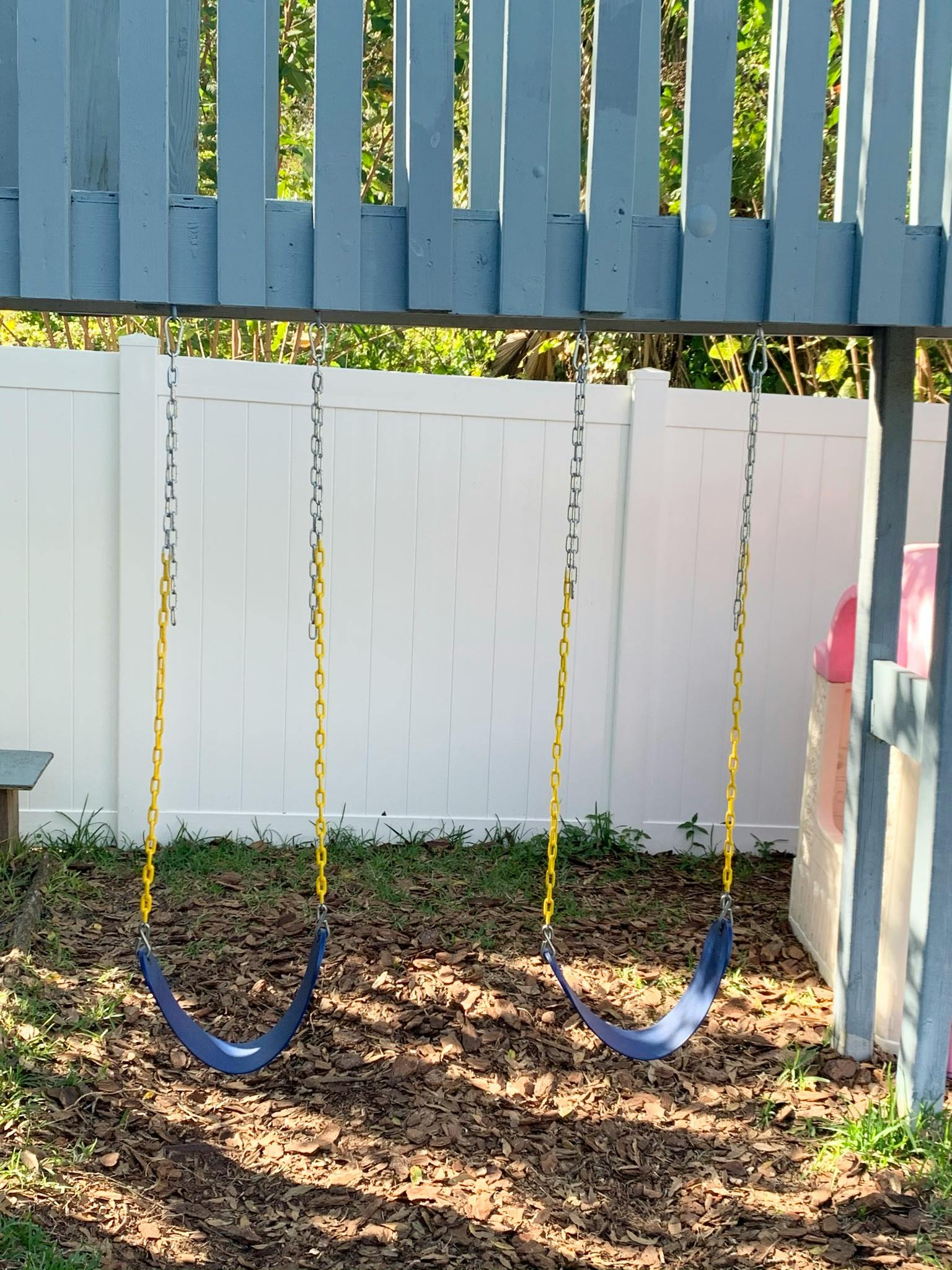 Three empty swings on a playground