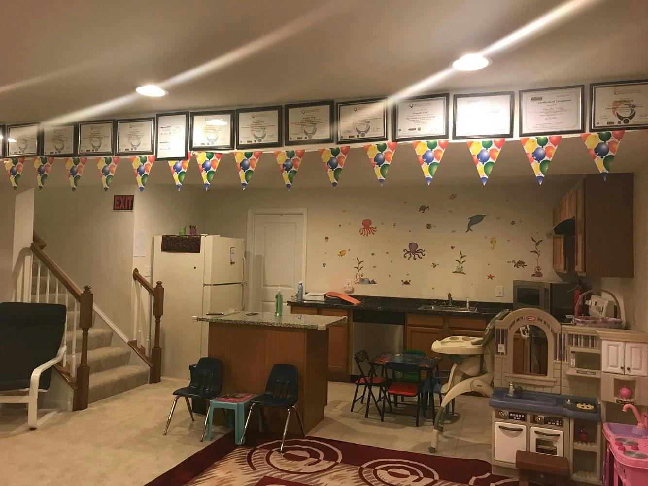 Basement room with stairs, kitchen area, and children's play kitchen