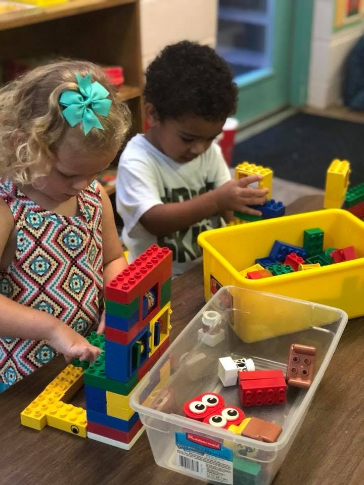 Two children playing with colorful building blocks