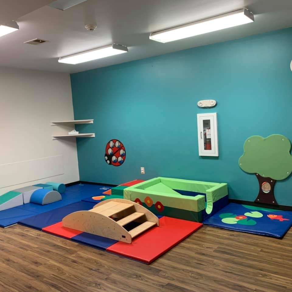 Indoor play area with soft mats, climbing structures, and a ball pit
