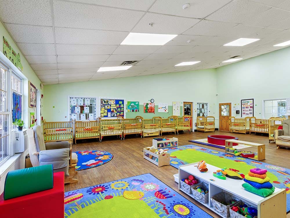 Cribs and play mats in a bright nursery room