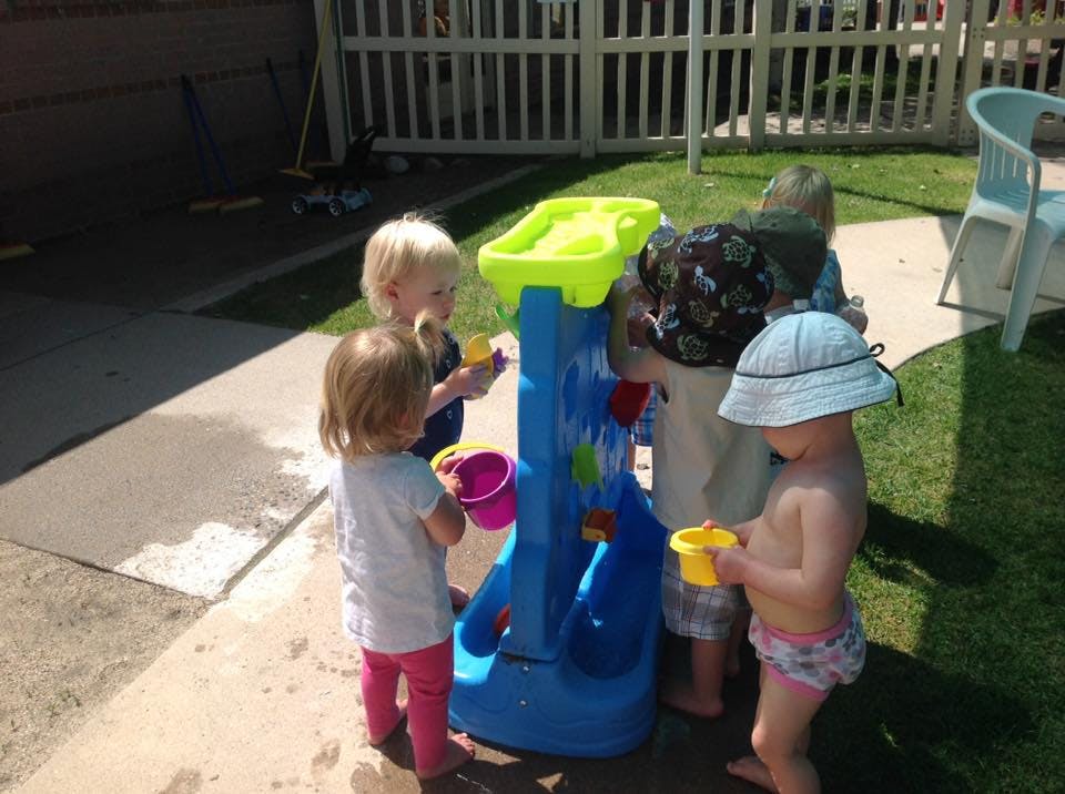 Children playing with a water table outdoors