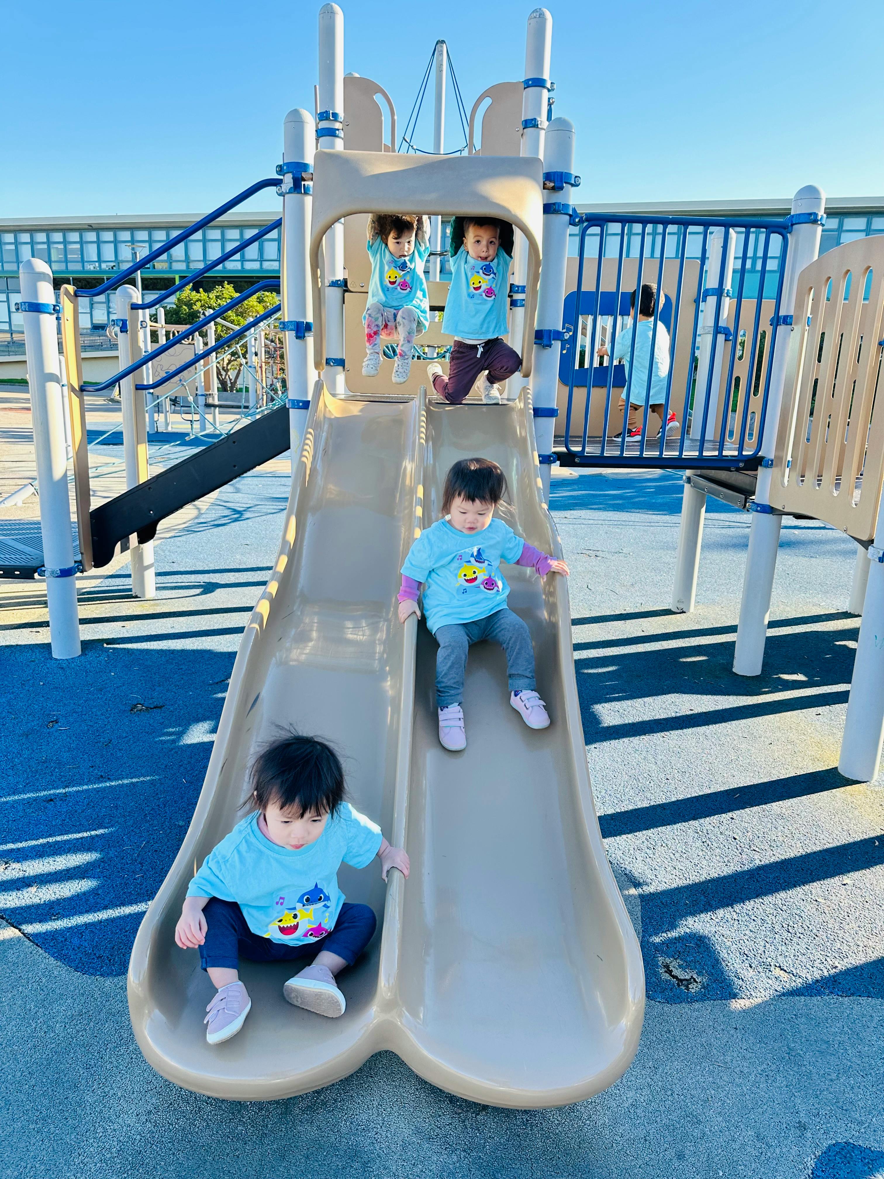 Three children on a playground slide structure
