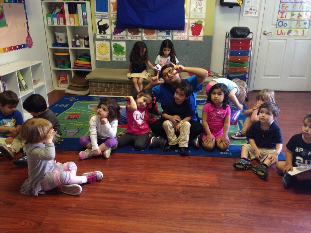 Adult and children sitting on the floor in a classroom