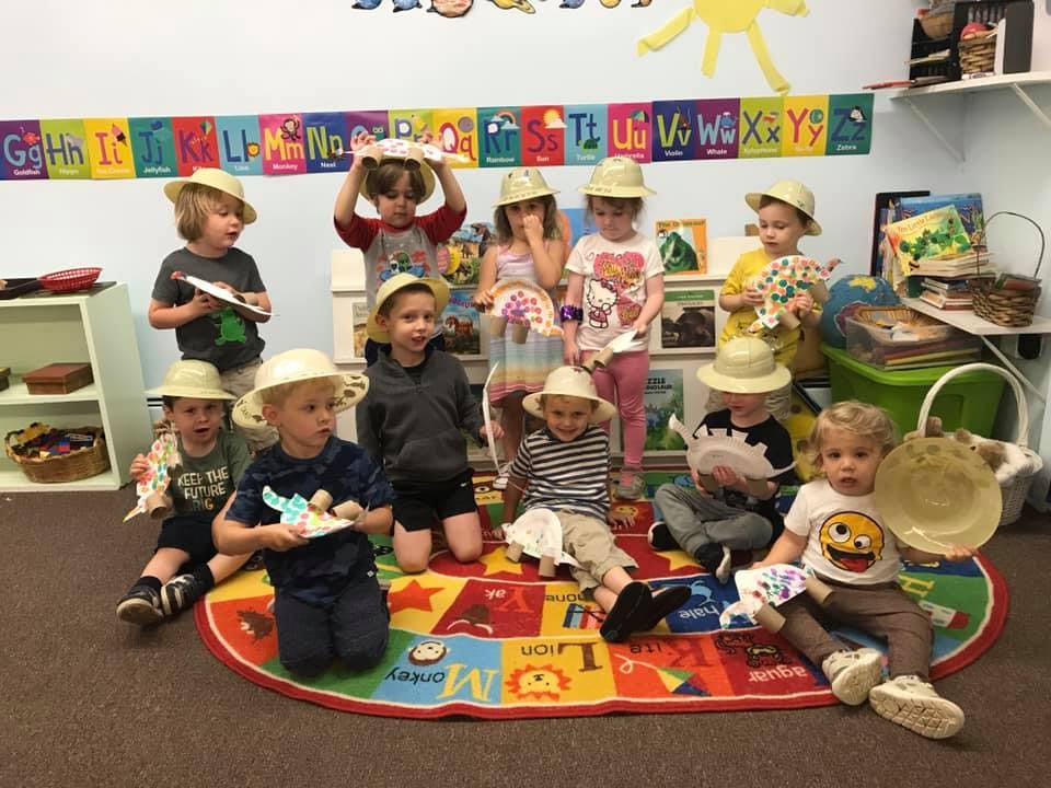 Group of children wearing hats in a classroom