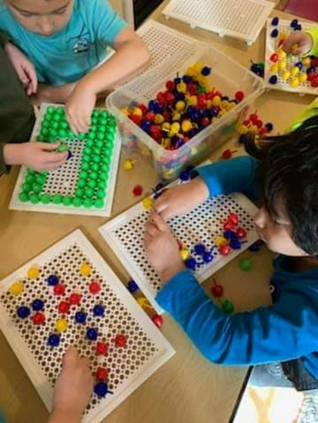 Children playing with pegboards and colorful pegs