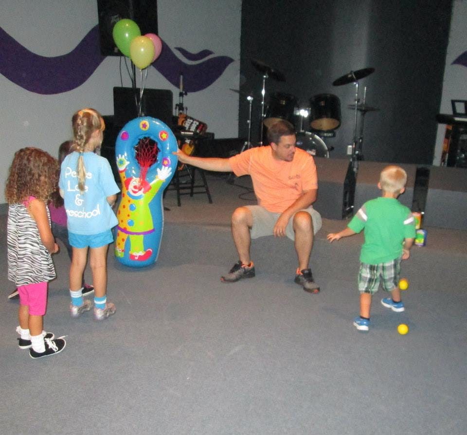Adult and children playing with an inflatable clown toy
